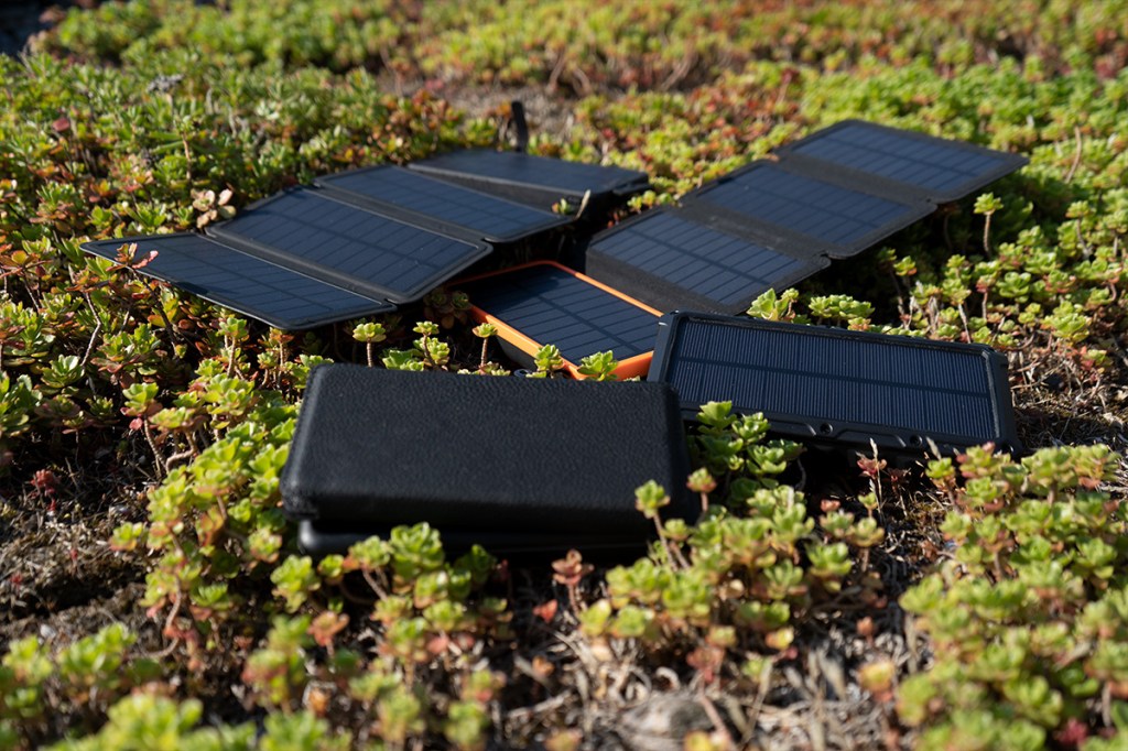 Die vier Solarpowerbanks liegen auf dem Rasen.
