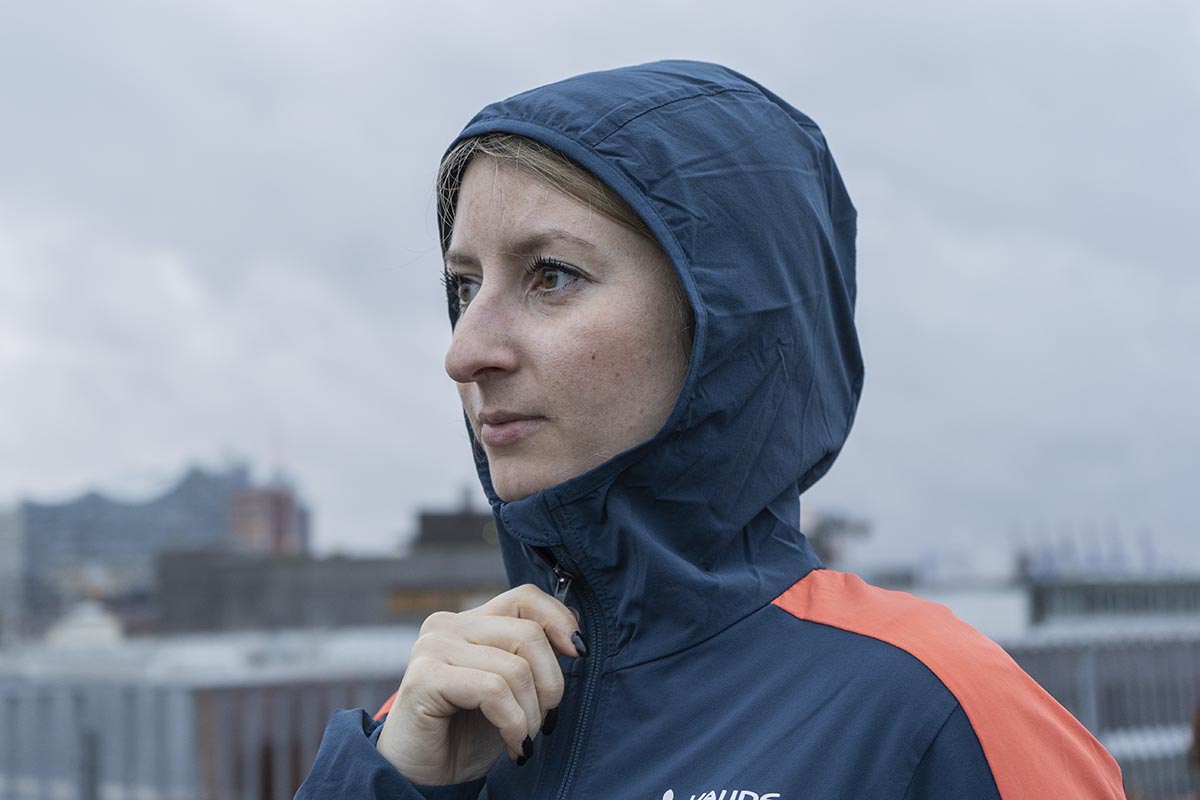 Detailbild Fau mit Sofshell-Jacke steht mit übergezogener Kapuze im Freien.