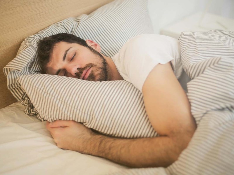 Nahaufnahme schlafender Mann in einem Bett