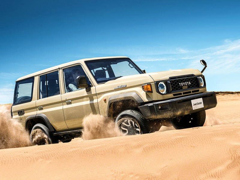 Das Facelift des neuen Land Cruiser 70 in der Wüste, vor blauem Himmel fotografiert.