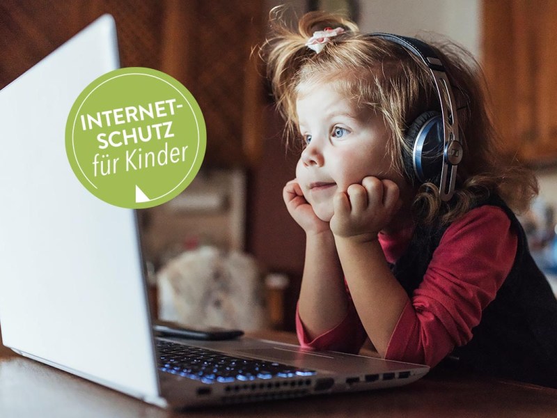 Sitzendes Kind vor einem Laptop mit Kopfhörern.