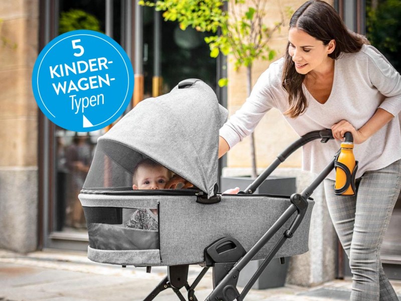 Kind in einem Wagen, der von einer Frau geschoben wird.