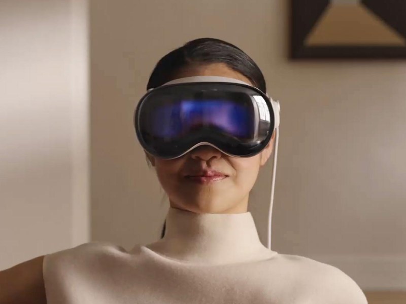 Person mit aufgesetzter Apple Vision Pro.