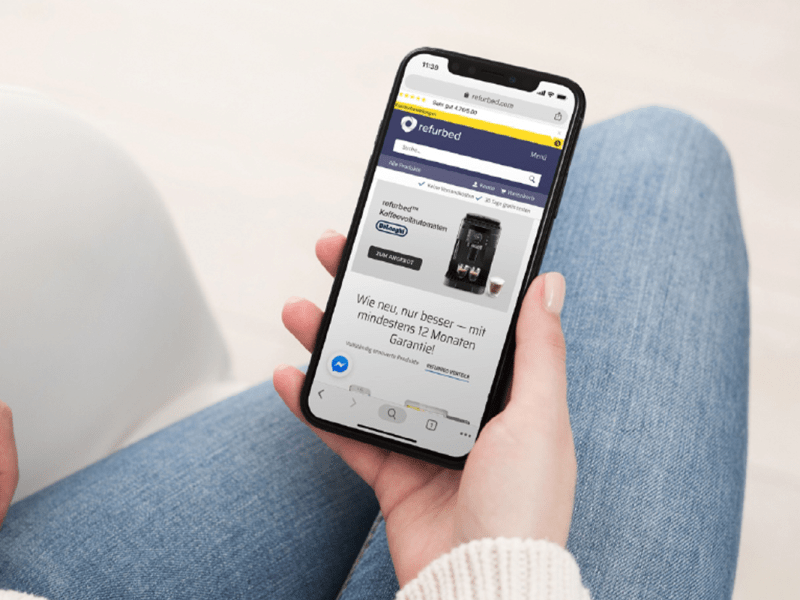 Auf einem Smartphone wird die Refurbed.de Website angezeigt.