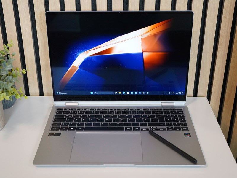 Ein eingeschaltetes Notebook auf einem weißen Tisch.