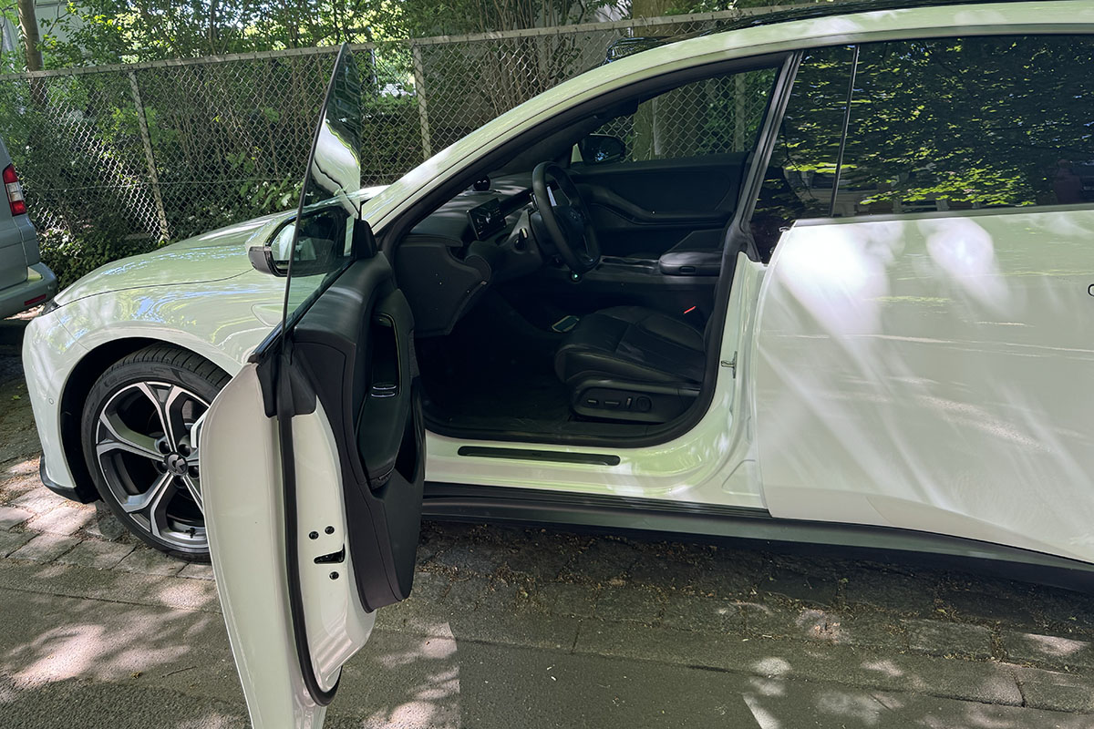 Detailaufnahme von geöffneter vorderer Seitentür auf Fahrerseite bei parkendem E-Auto Nio ET5 Touring.