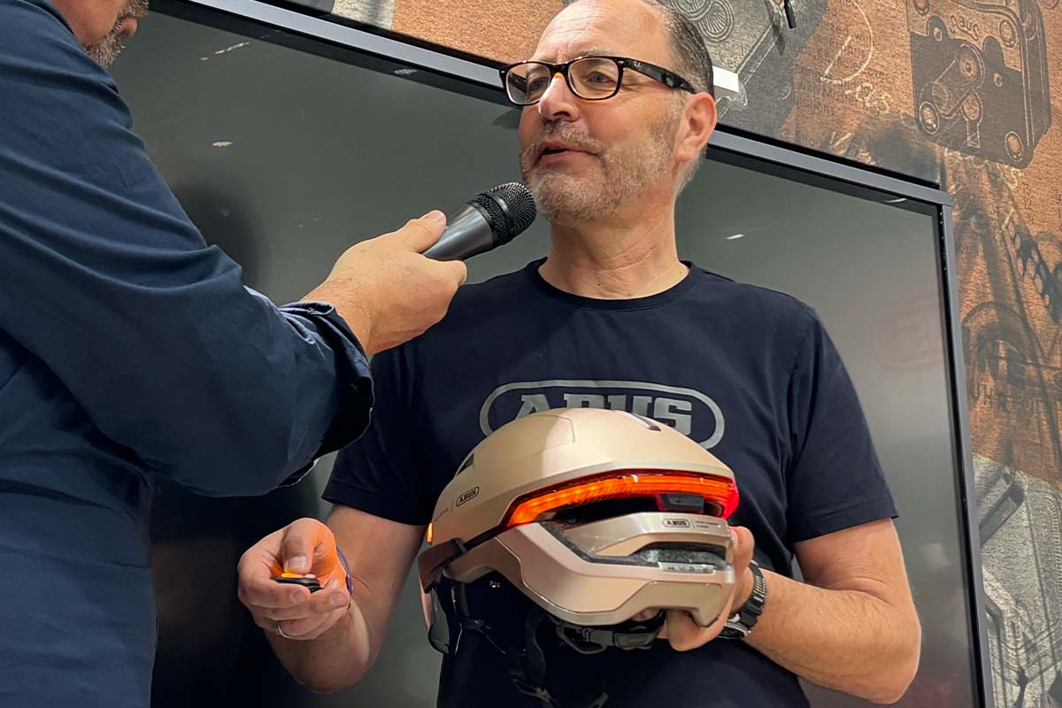 Mann wird gerade interviewed, er hält einen Fahrradhelm in der Hand