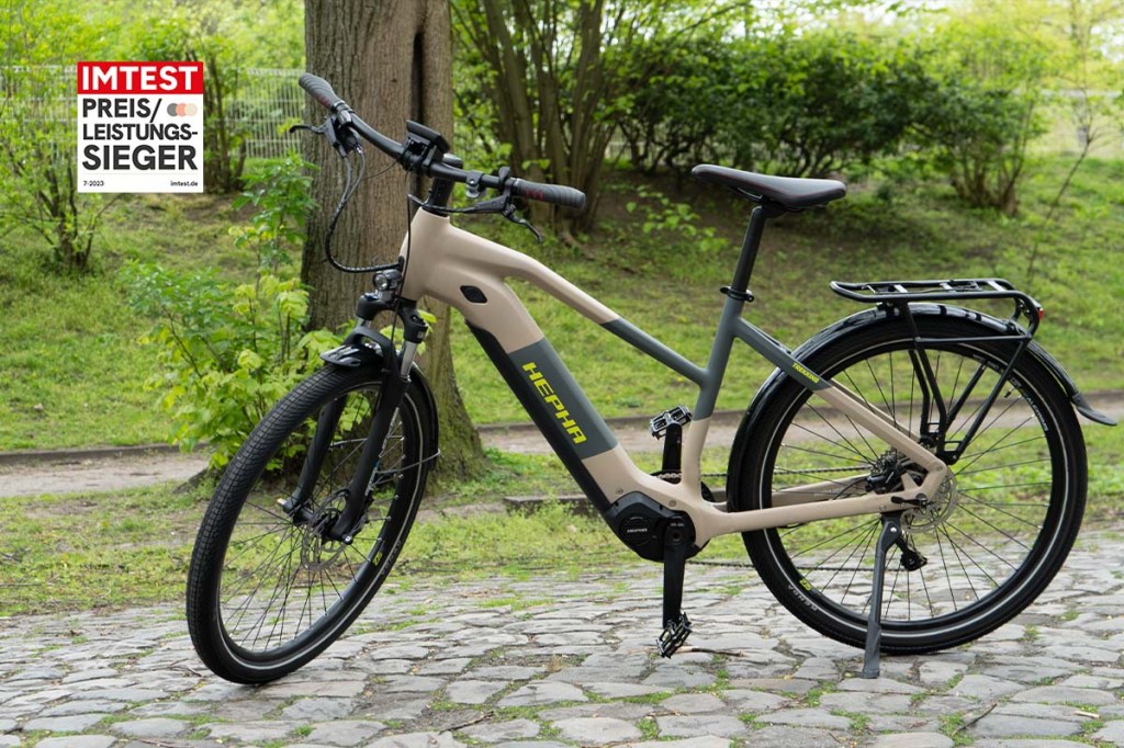 Trekking-E-Bike auf einer Straße stehend, Bäume in Hintergrund, dazu Preis-Leistungssieger-Siegel